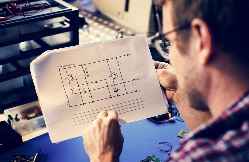 Technician man looking at resistor circuit on paper